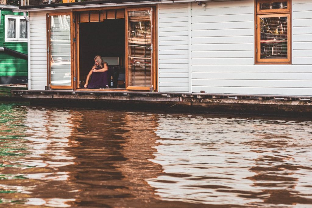 pexels photo 30201114 Woman relaxing on a houseboat in Amsterdam, enjoying a serene moment by the canal.