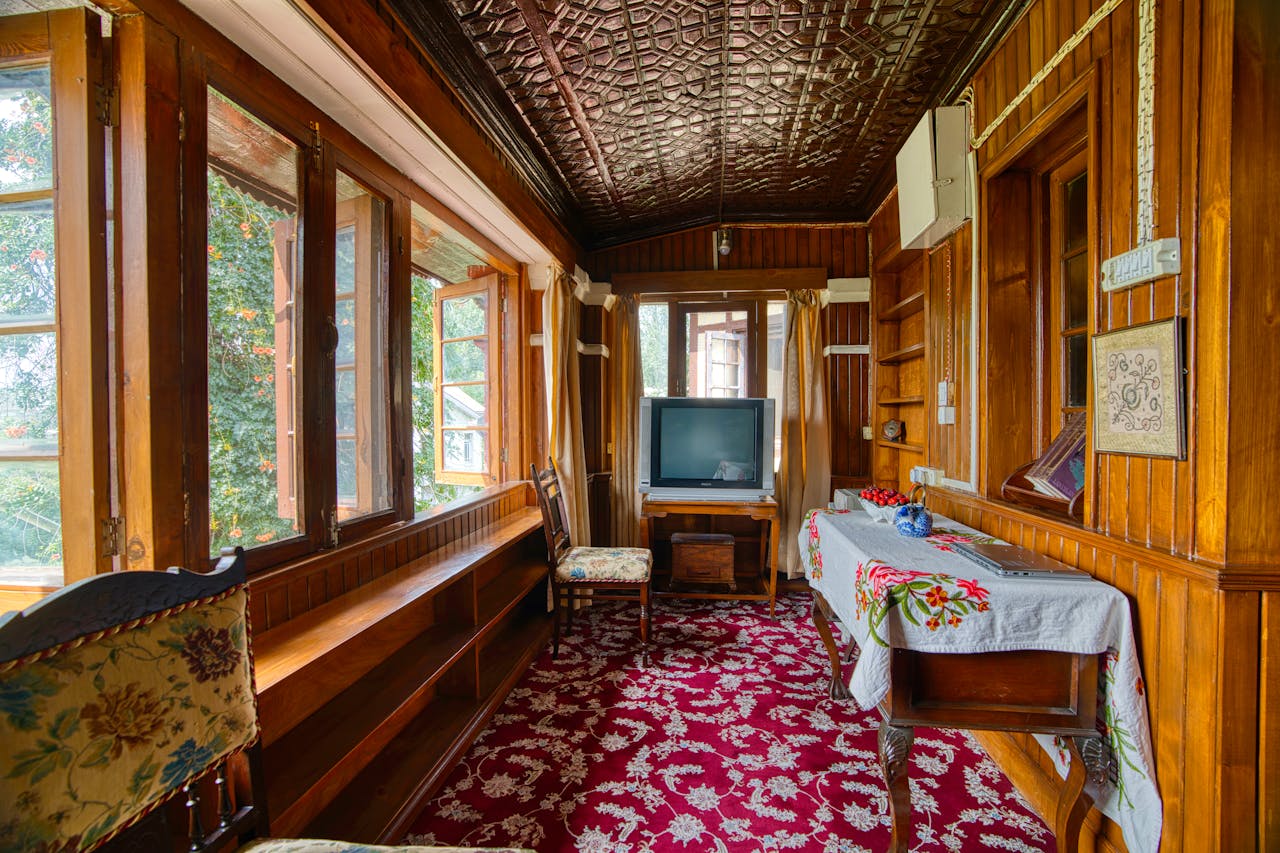 Home Charming wooden interior of a Kashmir houseboat with vintage decor and open windows.